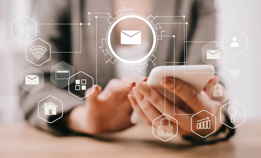Detailný pohľad na používateľku pracujúcu so smartfónom v rámci prepojeného digitálneho prostredia s ikonami e-mailu, cloudu a bezpečnosti – symbol efektívnej komunikácie a správy dát v systémoch Seyfor.