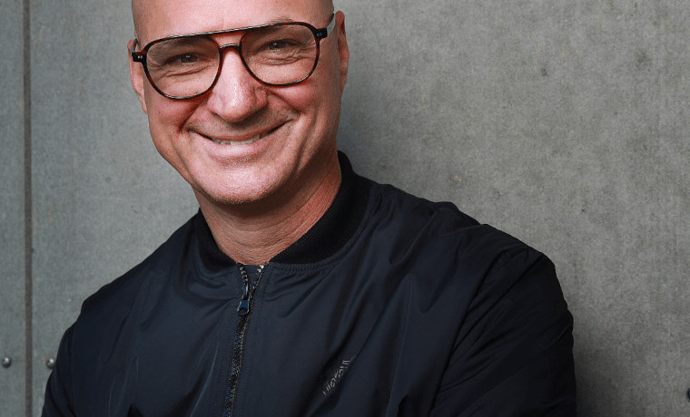 Smějící se muž v černé bundě a s brýlemi