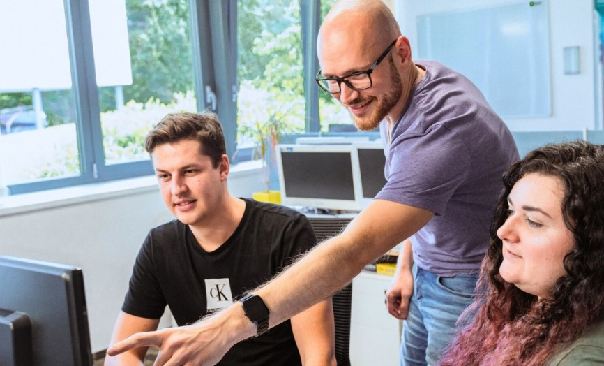 tři lidé u pracovního počítače