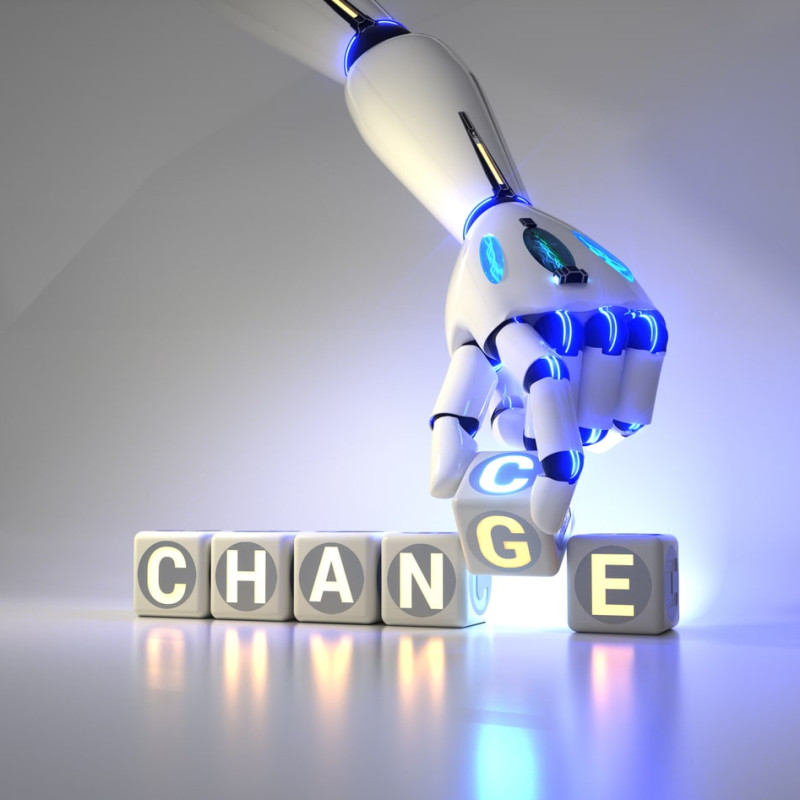 Robotická ruka měnící nápis CHANGE na CHANCE pomocí svítících kostek – symbol digitální transformace a nových příležitostí v éře automatizace.