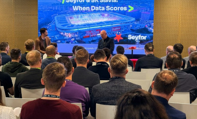 Účastníci sledují panelovou diskusi Seyfor & SK Slavia: When Data Scores s prezentací stadionu na velké obrazovce