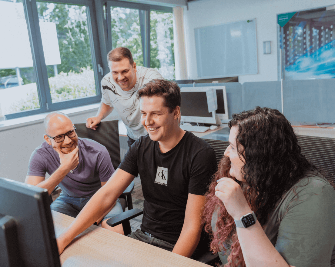 osoby v moderní kanceláři sledují společně monitor, týmová spolupráce a pracovní prostředí