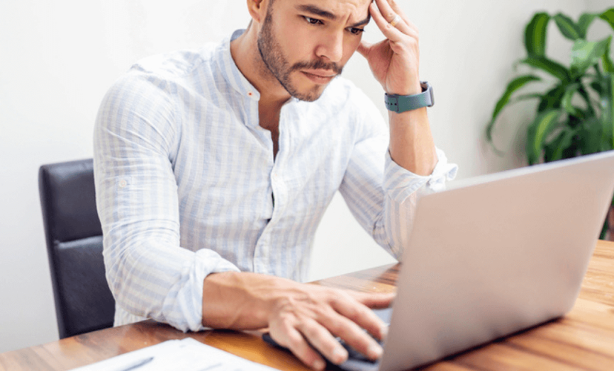 Můž, který frustrovaně kouká do notebooku